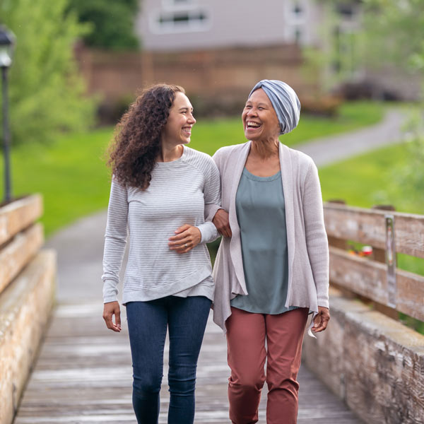 Two women walk together on a bridge