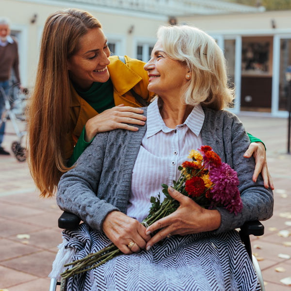 A old woman smiles while watching young girl